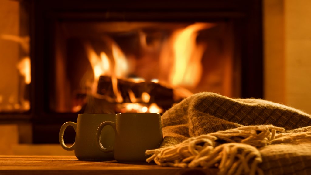 Steam from a cups with a hot cocoa on the fireplace background outdoor space